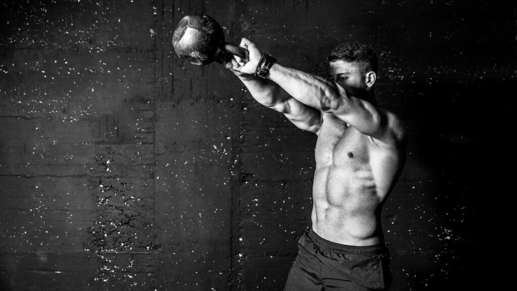 A Black and White image of a Man swinging a kettlebell