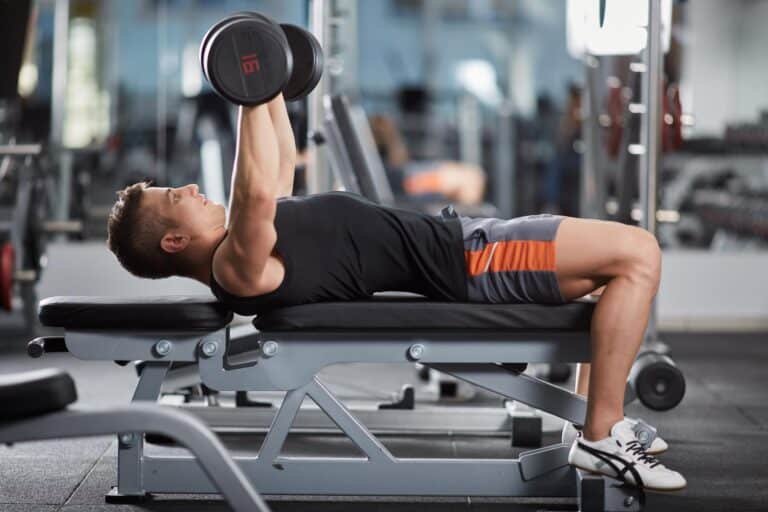 Man performing flat dumbbell press