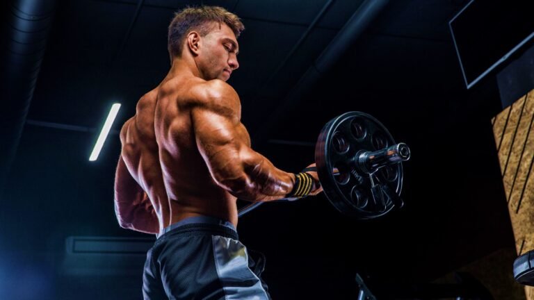 Muscular body builder doing barbell curls