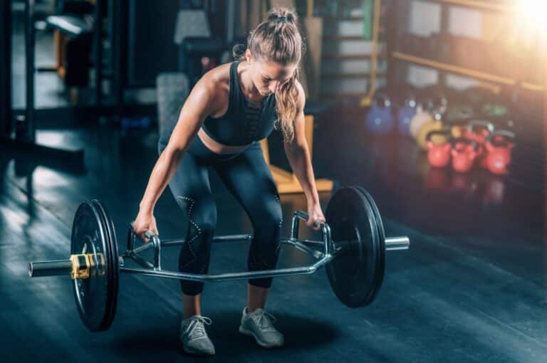 A woman doing the trap bar deadlift